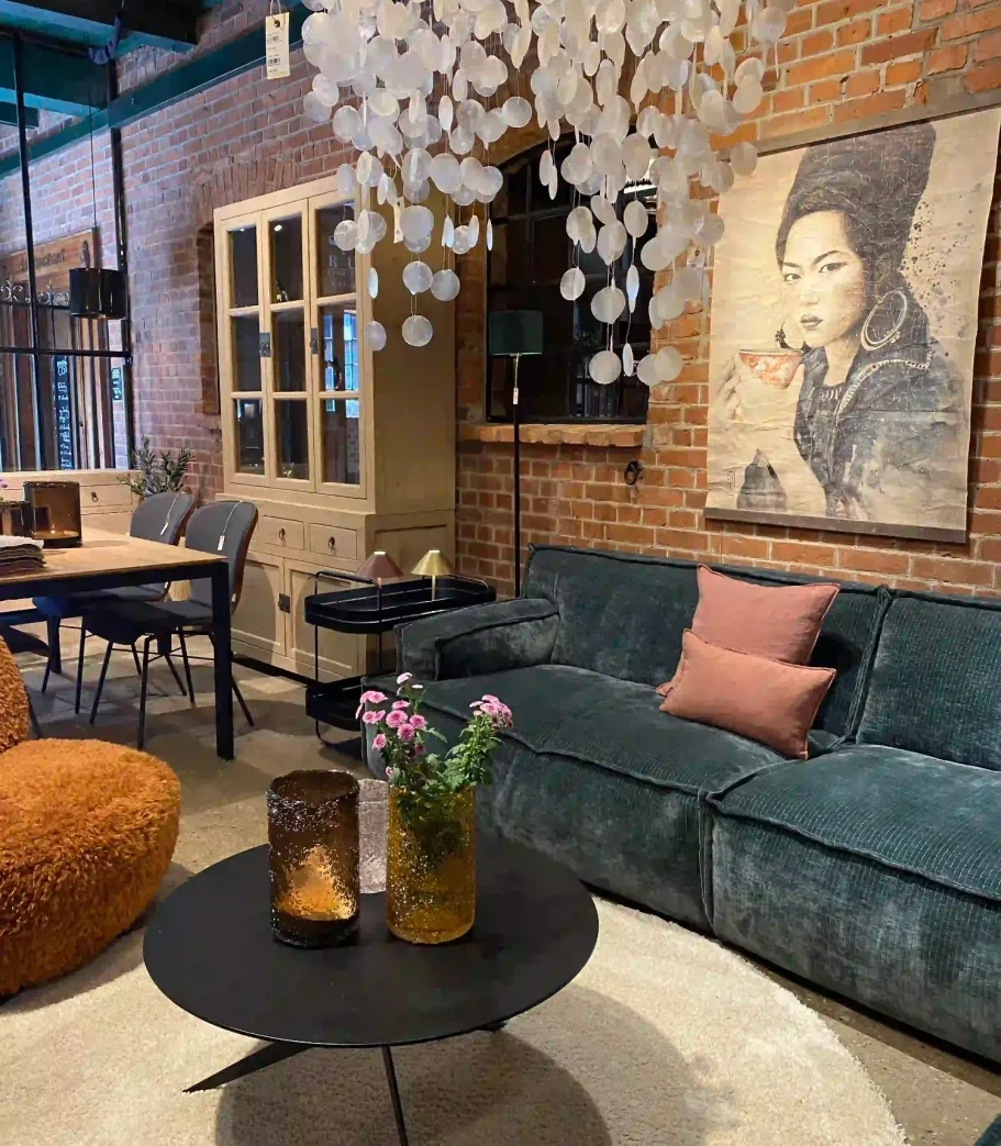 Moderne Wohnzimmeransicht mit Sofa, Tisch, Dekoration und Wandkunst.