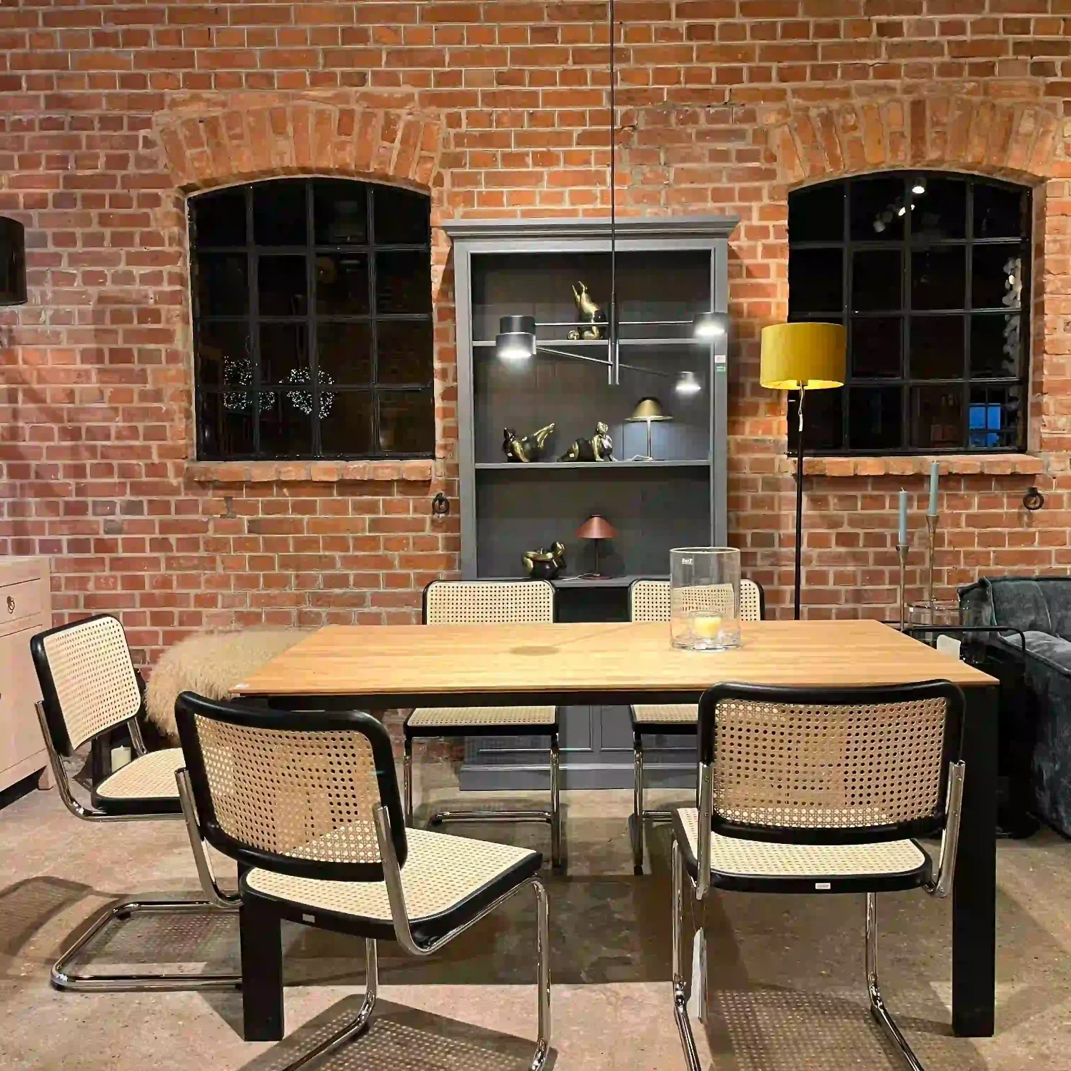 Thonet-Stühle Ein moderner Essbereich mit einem Tisch und Stühlen von Thonet vor einer Backsteinwand.